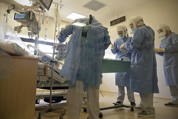 ​Medical staff in an isolation room at Singapore General Hospital preparing to intubate a suspected Covid-19 patient to help him breathe better. ST PHOTO NEO XIAOBIN